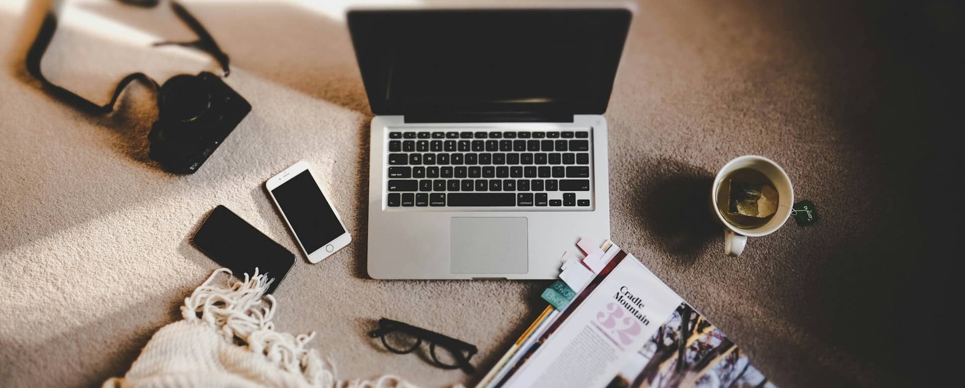 Ordinateur, téléphone et magazine réunis sur une table, symbolisant la transmission d’éclairages d’experts, d’avis éditoriaux et de repères pour anticiper les évolutions métiers.