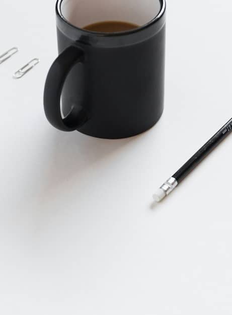 Mug noir, trombone et stylo, symbole de la qualité de vie au travail, priorité d’une organisation performante.