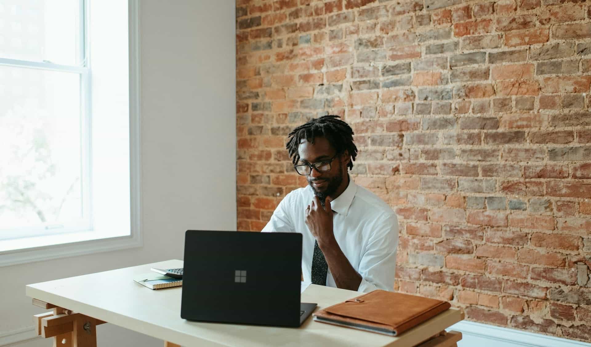 Futur formateur devant un ordinateur et calculatrice en main, étudiant les méthodes pédagogiques pour parler de la gestion des budgets du CSE.