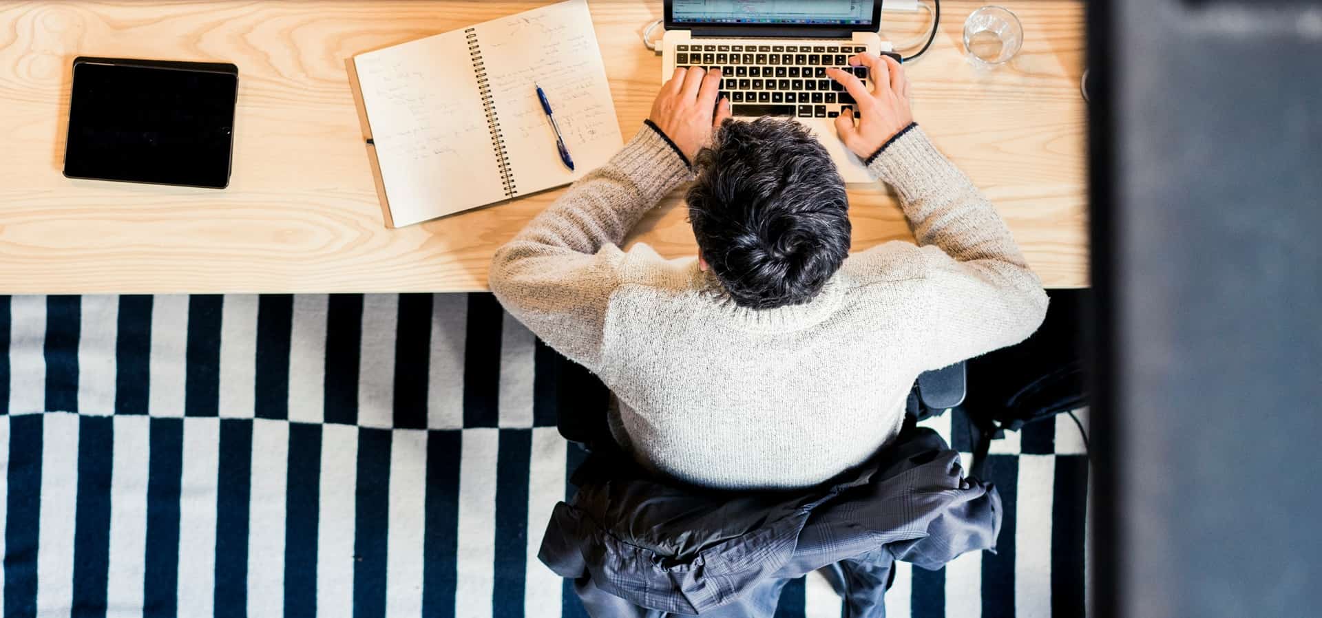 Homme recopiant manuellement des informations lors d’une démarche d’enregistrement administratif.