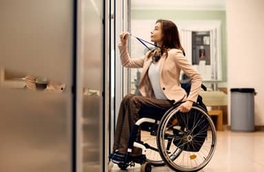 Employé à mobilité réduite accédant à son casier, démontrant l'importance de l'inclusion et de la conformité aux normes d’accessibilité des environnements de travail.