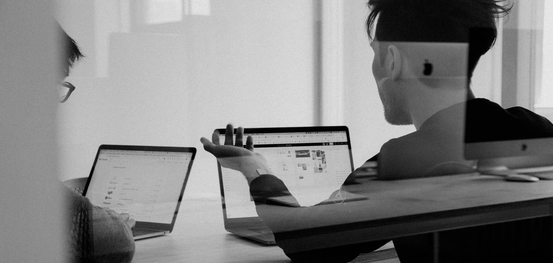 Échange pédagogique entre un formateur et un stagiaire côte à côte dans un contexte d’accompagnement personnalisé.