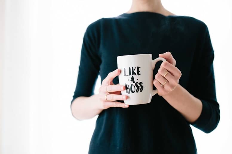 Formatrice CSE indépendante tenant un mug « like a boss », symbole d’un départ entrepreneurial motivé et confiant