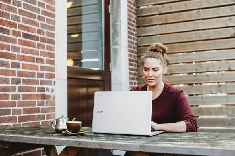 Femme en télétravail sur sa terrasse mettant en application des conseils pratiques pour intégrer la QVCT dans la politique RH.
