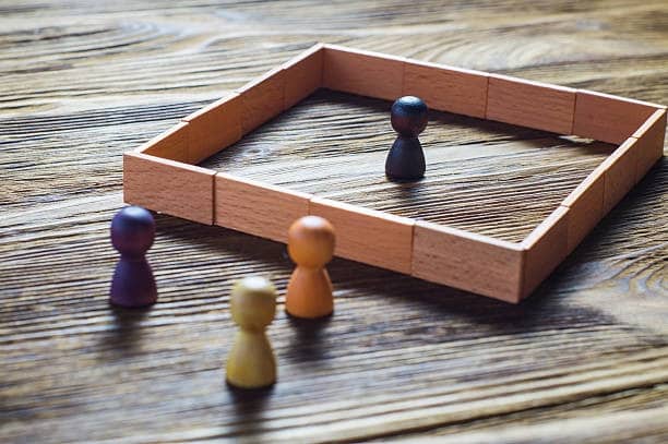 Pions colorés, un isolé dans un carré, symbolisant une formation sur la lutte contre les discriminations au travail.